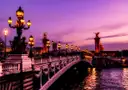 The lamps of Pont Alexandre III glowing over the Seine at dusk