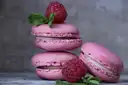 Pink macarons stacked with fresh raspberries and mint