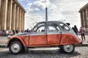 A red and cream Citroën 2CV at Trocadéro, the Eiffel Tower behind it
