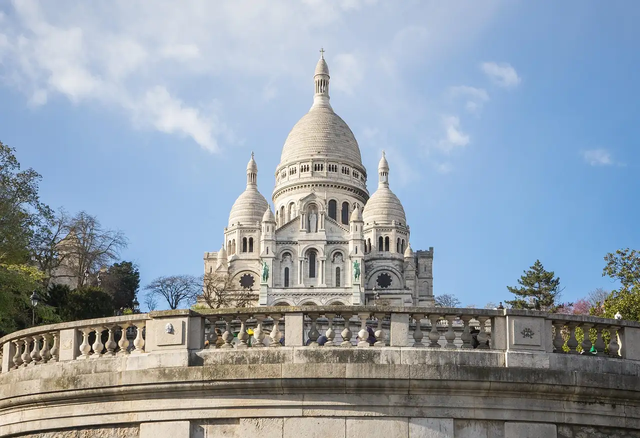 The white domes of the Sacré-Cœur above a curved stone balustrade