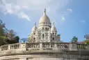 The white domes of the Sacré-Cœur above a curved stone balustrade