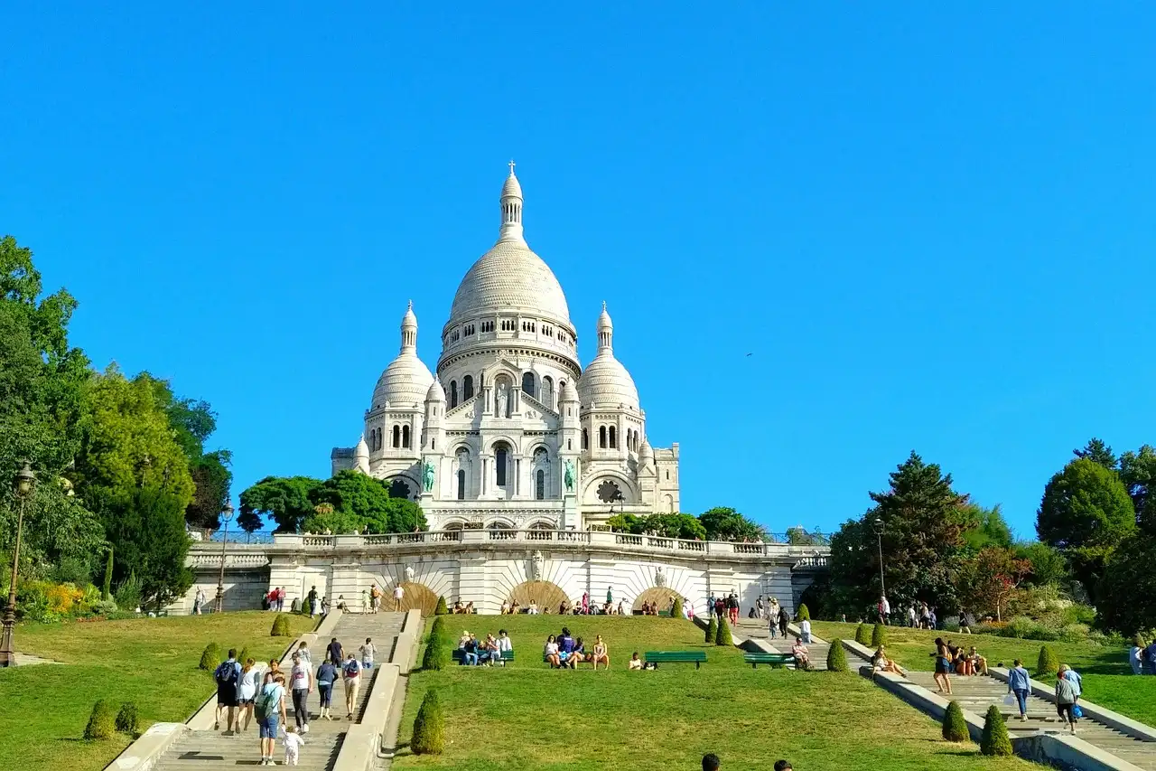 The white Sacré-Cœur basilica above the green lawns of Montmartre