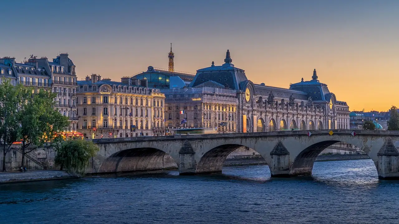 The Musée d'Orsay and a stone bridge over the Seine at dusk