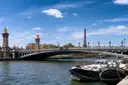 The Pont Alexandre III and moored boats on the Seine, the Eiffel Tower in the distance