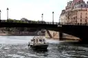 A small boat passing under a bridge on the Seine
