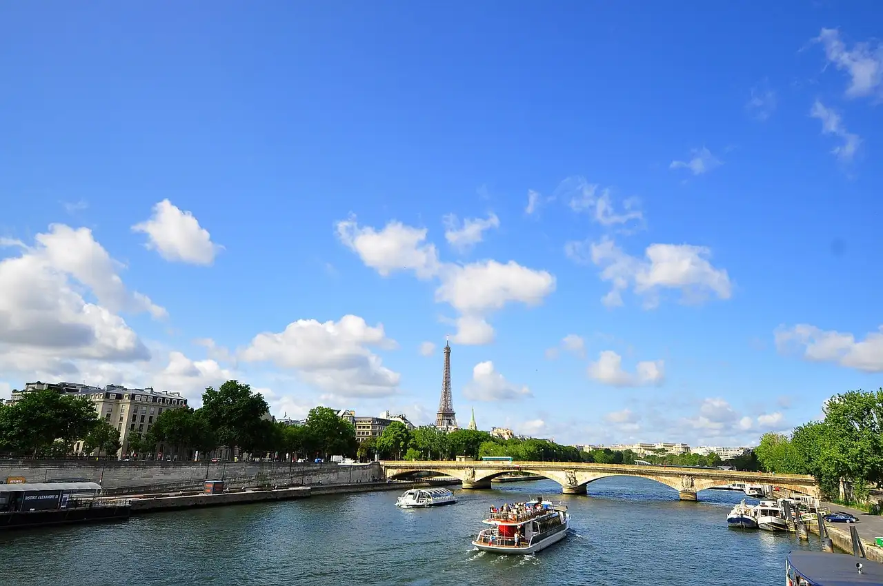 A tour boat on the Seine on a sunny day, with the Eiffel Tower in the distance
