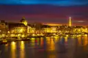 The Seine and its quays lit up at dusk with the Eiffel Tower in the distance
