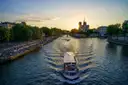 A river boat cruising the Seine at sunset toward Notre-Dame