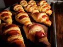 Freshly baked croissants lined up on a baking tray