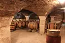 Oak wine barrels under the stone vaults of an old wine cellar