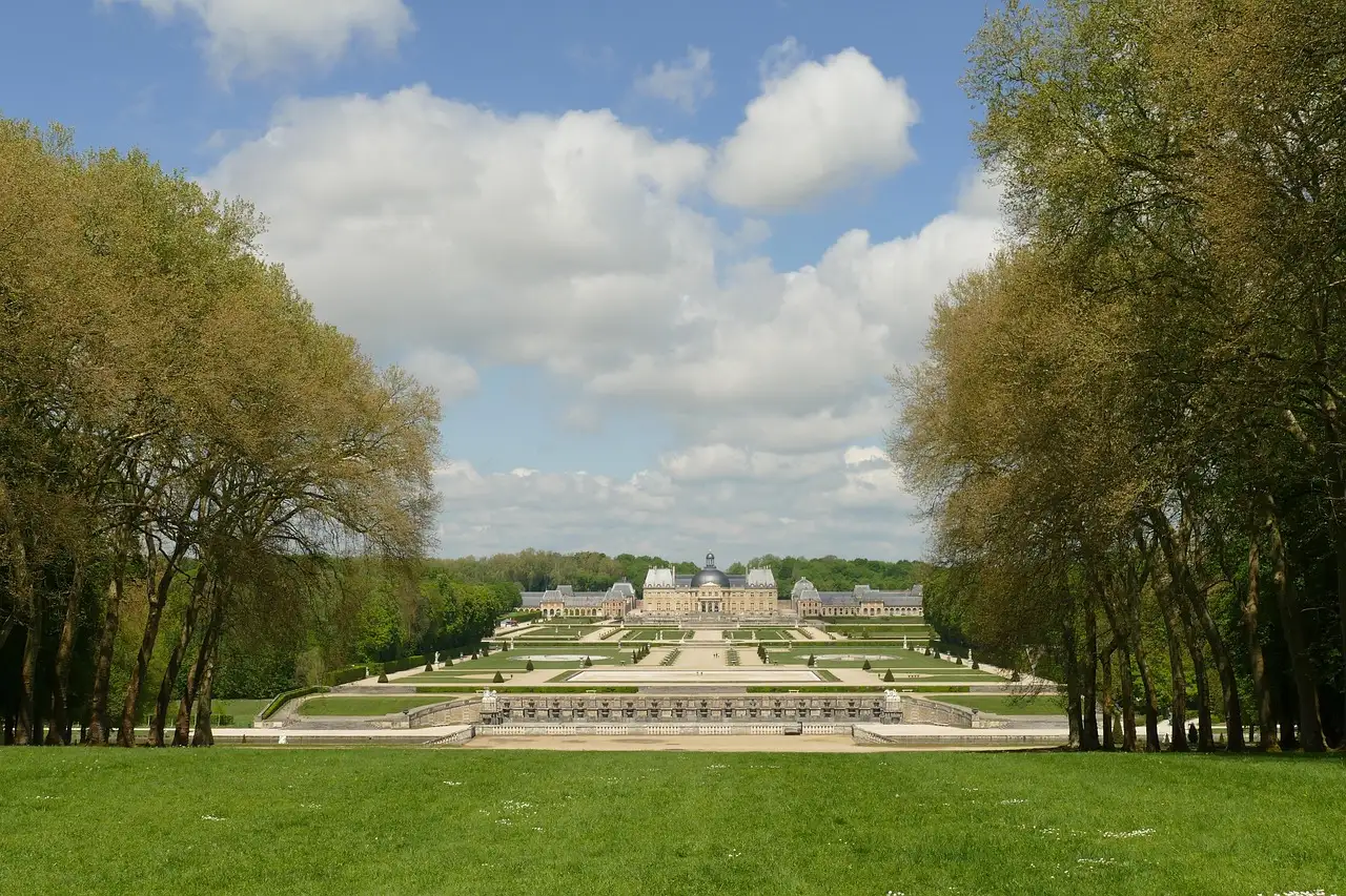 The formal gardens of Vaux-le-Vicomte stretching away between tall trees