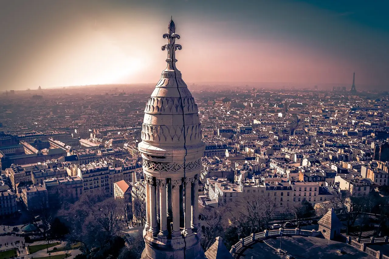 View from the Sacré-Cœur dome over the rooftops of Paris in hazy evening light